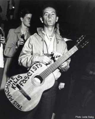 Woody Guthrie with nylon string 00 circa 1941 with “This Guitar Kills Fascists”